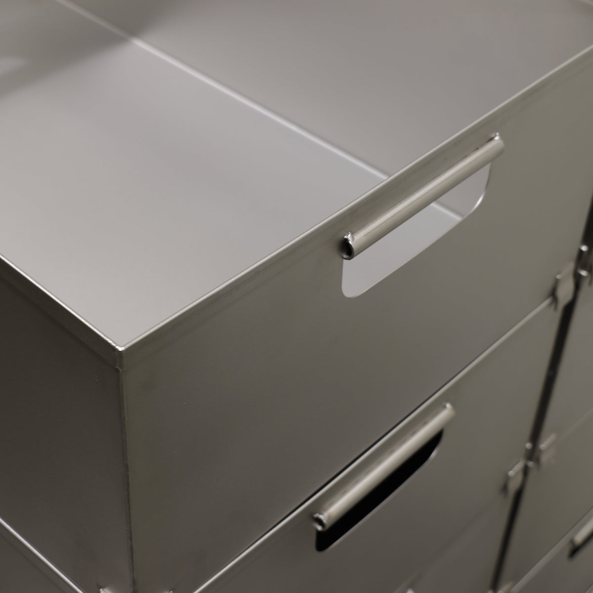 Close-up of a stainless steel crate showing its integrated handhold cut-outs